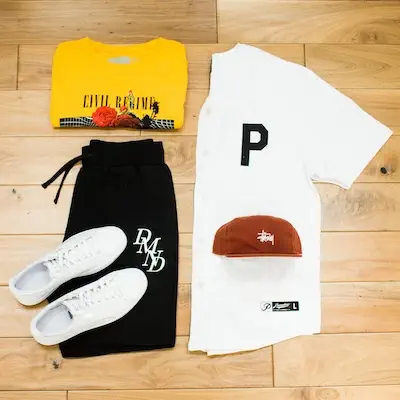 clothes black shorts, white sneakers, white shirt, brown hat and yellow shirt